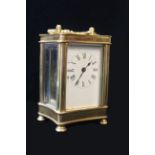 A 20th CENTURY GILT BRASS CARRIAGE CLOCK, having a curved rectangular case And four bevelled glass