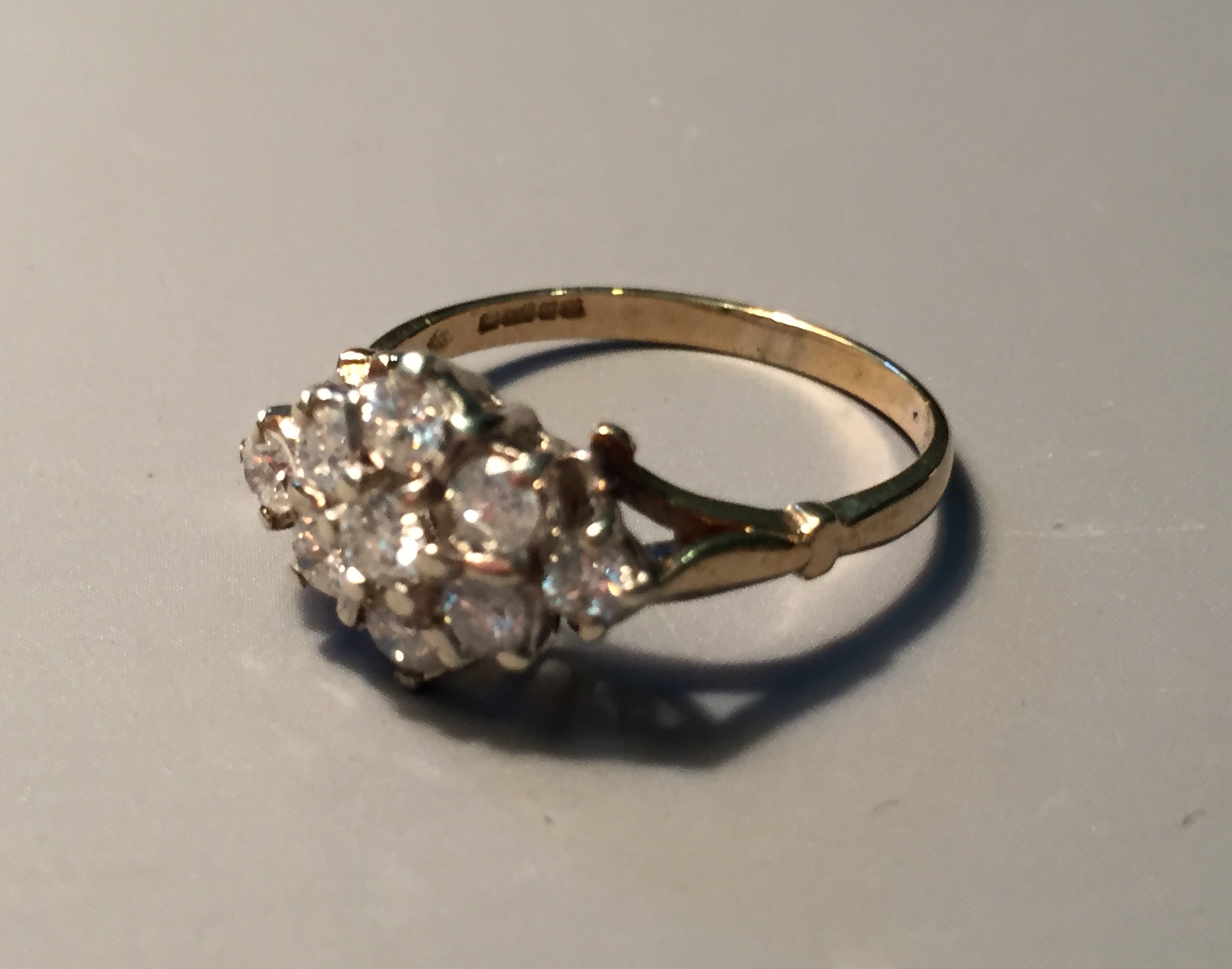 A 9CT GOLD AND DIAMOND CLUSTER RING The lozenge shaped bezel set with nine stones (size N).