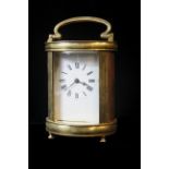 A 20th CENTURY GILT BRASS CYLINDRICAL CARRIAGE CLOCK, having a rectangular white dial with black