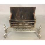 A REGENCY DESIGN POLISHED STEEL FIRE GRATE With turned finials and pierced fretwork apron, raised on