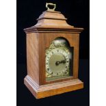 A 20th CENTURY OAK MINIATURE BRACKET CLOCK, having a brass carry handle,the silvered brass dial