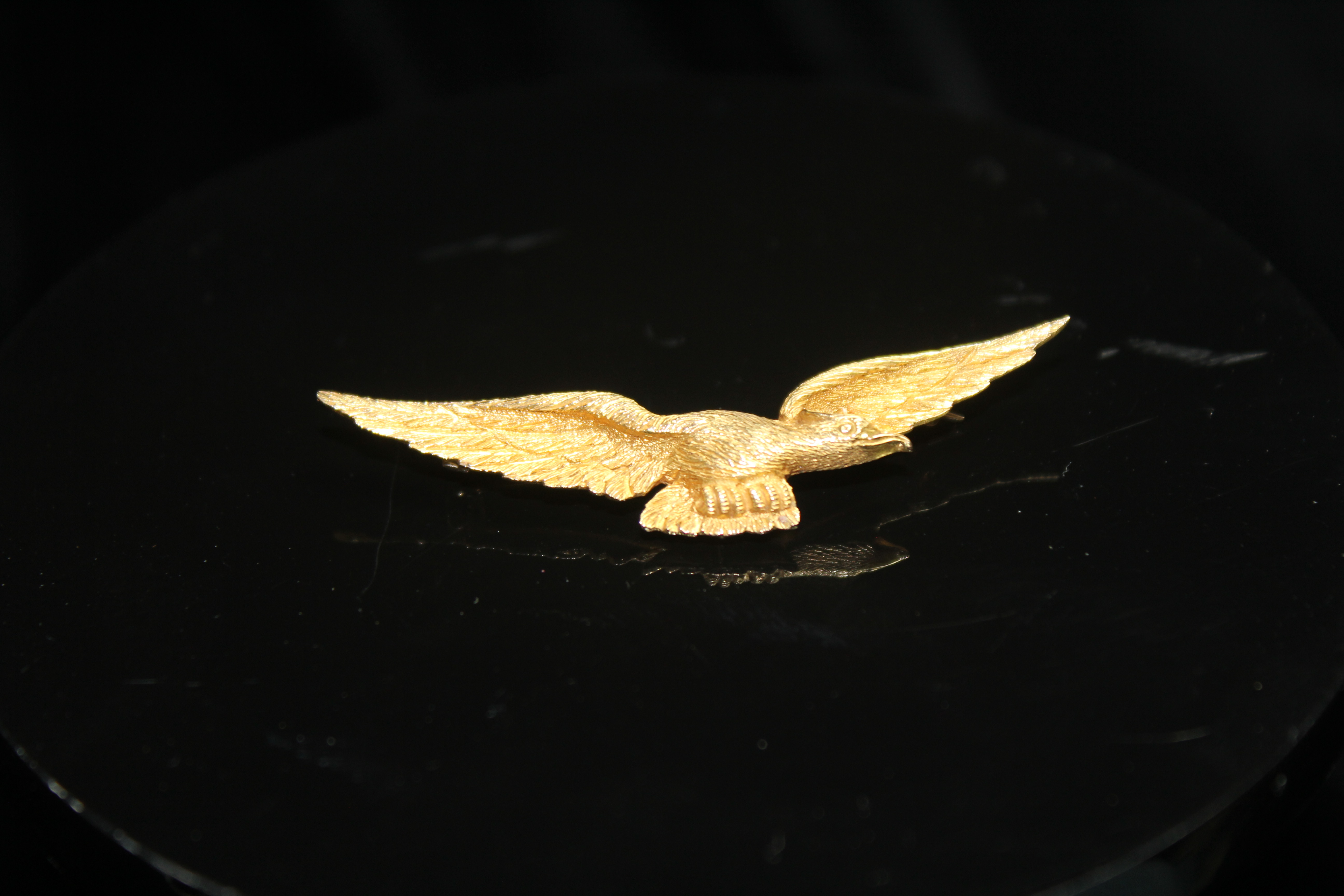 AN EARLY 20TH CENTURY GOLD BROOCH, in the form of an eagle in flight. Stamped '15ct' to the reverse.