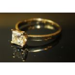AN 18ct GOLD AND DIAMOND SOLITAIRE RING, having a princess cut diamond held in a plain gold shank