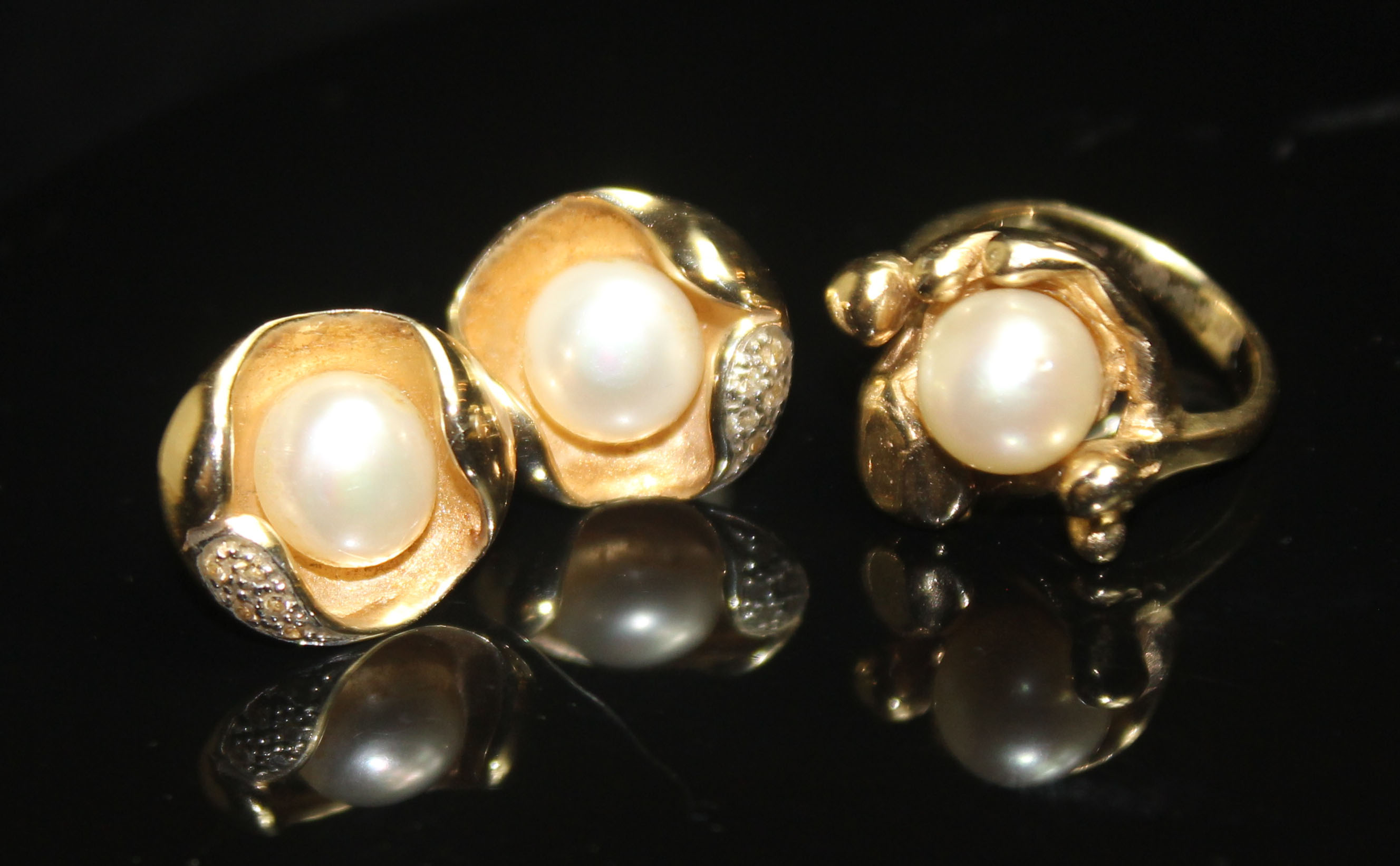 A MODERNIST 9CT GOLD AND PEARL DRESS RING. A single 7.6mm pearl in an organic, abstract mount to a