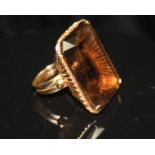 A LARGE VINTAGE SMOKY QUARTZ COCKTAIL RING. The large rectangular mixed-cut quartz in a four-claw