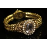 AN AMETHYST, PEARL AND YELLOW METAL BRACELET. An oval, mixed-cut amethyst in a pearl surround