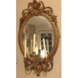 A 19TH CENTURY GILT FRAMED GIRONDEL MIRROR, crested with a floral cartouche above three candle