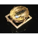 A LARGE VINTAGE CITRINE AND GOLD PANEL BROOCH. The large oval mixed-cut citrine in a high four-