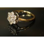 AN 18ct GOLD AND DIAMOND CLUSTER RING, having an arrangement of round cut diamonds forming a daisy