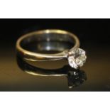 AN 18CT GOLD AND DIAMOND SOLITAIRE RING Having a single round cut diamond set in a three prong