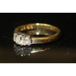 AN 18CT GOLD AND DIAMOND THREE STONE RING Having three cushion cut diamonds of graduated size.