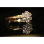 AN 18ct GOLD AND DIAMOND CLUSTER RING, having an arrangement of diamonds held in a daisy style mount