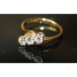 AN 18CT GOLD CROSSOVER RING SET WITH THREE DIAMONDS . size m