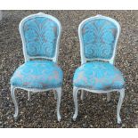 A PAIR OF FRENCH BEDROOM CHAIRS with cream painted frames, upholstered in a cut moquette