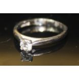 A 9CT WHITE GOLD AND DIAMOND SOLITAIRE RING Having a single round cut diamond set in a claw clasp