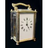 A 20th CENTURY GILT BRASS CARRIAGE CLOCK, of plain design with square glass aperture. Approx 10cm