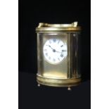 A 20th CENTURY GILT BRASS CYLINDRICAL CARRIAGE CLOCK, having a circular white dial with Roman