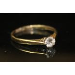 A 9CT GOLD AND DIAMOND SOLITAIRE RING With single round cut diamond set on six prong clasp flanked