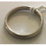 AN EARLY 20TH CENTURY PLATINUM WEDDING BAND Of simple form, the interior with incised initials: 'J.