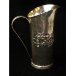 A HAMMERED SILVER ARTS AND CRAFTS PERIOD JUG , marked b r 925 sterling , decorated with a band of