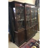 AN ANTIQUE MAHOGANY BREAKFRONT BOOKCASE The top with astragal glazed doors opening to reveal an