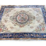 A 20TH CENTURY CHINESE WOOLLEN RUG The cream ground with blue floral border, the central field