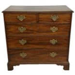 A GEORGE III SOLID MAHOGANY CHEST OF DRAWERS Having an arrangement of two short over three long