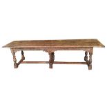 AN ANTIQUE SOLID YEW REFECTORY TABLE The four plank top above a carved frieze, raised on six