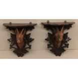 A PAIR OF 19TH CENTURY BLACK FOREST CARVED FIGURAL WALL BRACKETS Featuring rams heads and oak