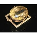 A LARGE VINTAGE CITRINE AND GOLD PANEL BROOCH The large oval mixed cut citrine in a high four claw