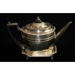 A GEORGIAN SILVER TEAPOT AND STAND Having an ebonized wood finial and handle, gadrooned border and