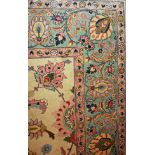 A LARGE TABRIZ WOOLLEN RUG OF CARPET PROPORTIONS Cream ground with floral decoration and turquoise