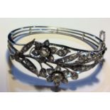 A VINTAGE 18CT WHITE GOLD AND DIAMOND BANGLE The arrangement of round cut diamonds forming a