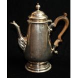 A GEORGIAN SILVER COFFEE POT Of plain tapering design with a brown fruitwood handle and fluted