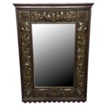 A LATE 19TH CENTURY OAK AND REPOUSSÉ BRASS FRAMED MIRROR The bevelled plate surrounded by
