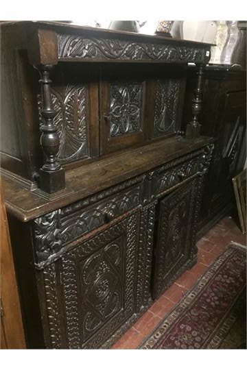 A 17TH CENTURY OAK COURT CUPBOARD With an arrangement of heavily carved doors and drawers. (135cm