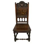 AN EDWARDIAN CARVED OAK TUDOR STYLE CHAIR Having a carved scrolled cartouche above an inlaid