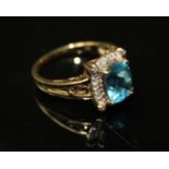 A VINTAGE 9CT GOLD AND AQUAMARINE RING Set with an oval cut stone and a row of paste stones (size