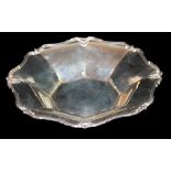 AN EARLY 20TH CENTURY SILVER OCTAGONAL BOWL With scalloped border set with shells and raised on four