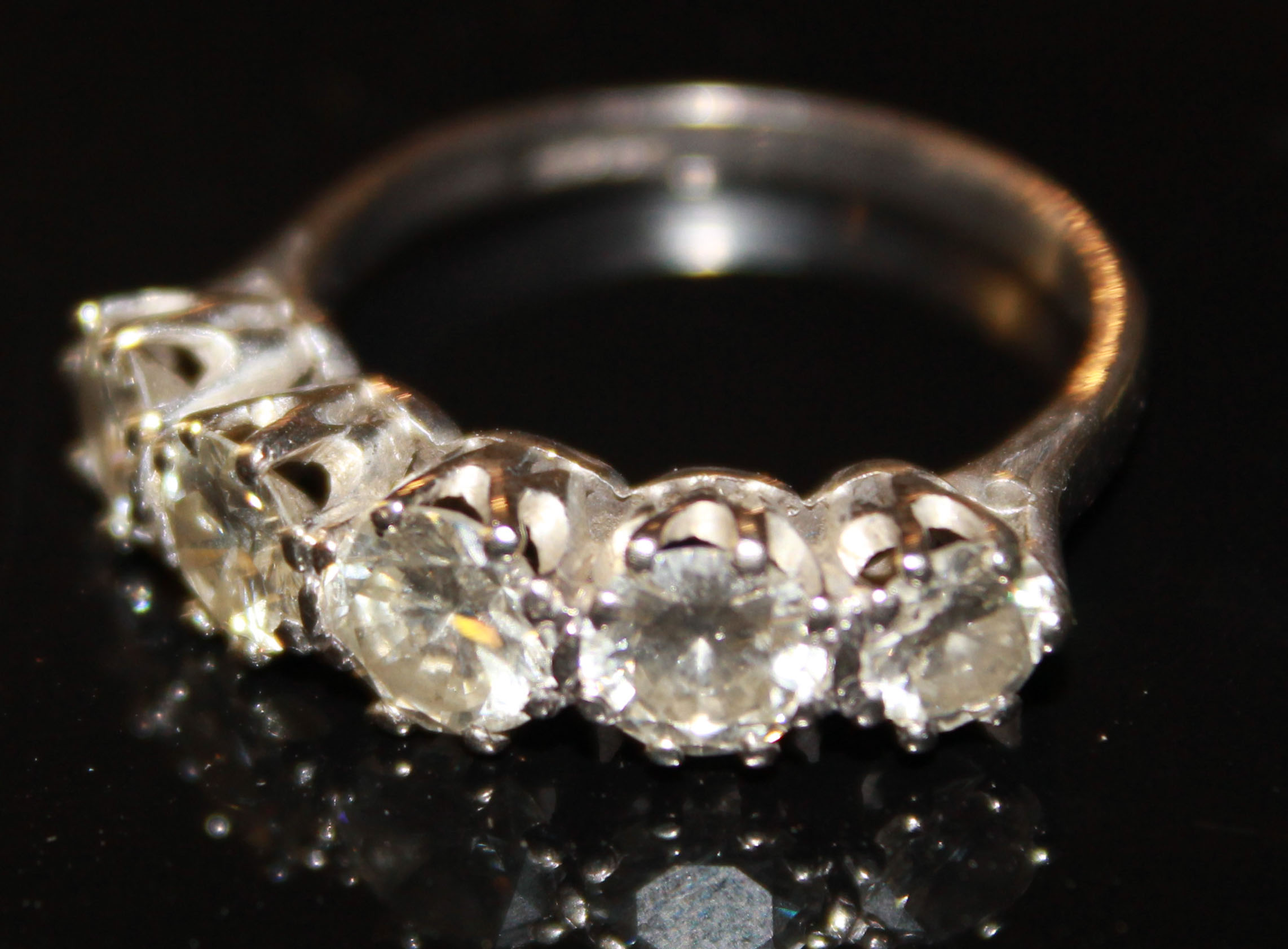 AN 18CT WHITE GOLD AND DIAMOND FIVE STONE RING The graduating round cut diamonds held in a raised