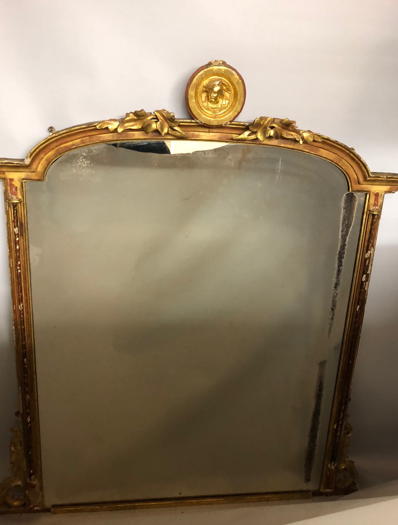 A 19TH CENTURY GILTWOOD OVERMANTEL MIRROR The arched top set with a gilt Tudor style portrait