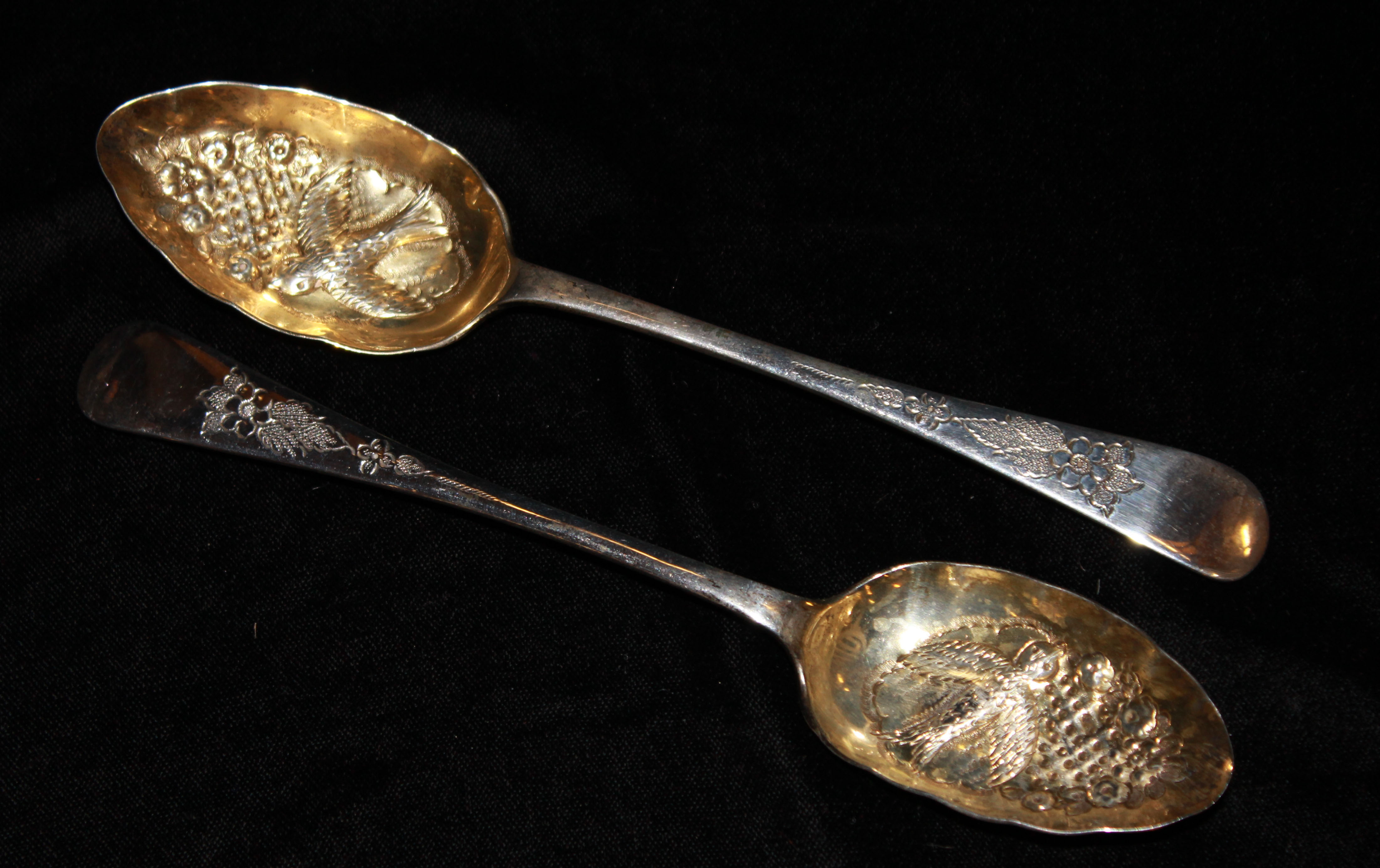 A PAIR OF EARLY 20TH CENTURY SILVER BERRY SPOONS The gilt bowls embossed with birds and flowers,