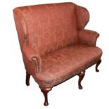 AN EARLY 20TH CENTURY MAHOGANY AND UPHOLSTERED GEORGE I DESIGN WINGBACK SETTEE With scrolling