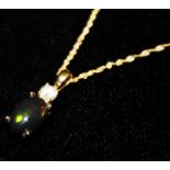 AN 18CT GOLD, DIAMOND AND BLACK OPAL SET PENDANT The cabochon cut opal set with a single round cut