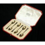 HARRODS, LONDON, A CASED SET OF SIX VINTAGE SILVER GILT TEASPOONS Having serpentine handles,