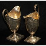 TWO GEORGIAN SILVER CREAM JUGS OF NEOCLASSICAL STYLE To include one helmet form with loop handle and