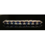 MAPPIN & WEBB, A VINTAGE WHITE METAL, SAPPHIRE AND DIAMOND BROOCH Having a single row of lozenge cut