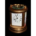 ELLIOT & SONS LONDON, A MINIATURE BRASS AND PORCUPINE CIRCULAR CARRIAGE CLOCK. (h 12cm x w 7cm)