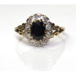 A VINTAGE 9CT GOLD, SAPPHIRE AND DIAMOND CLUSTER RING Having an oval cut sapphire surrounded by