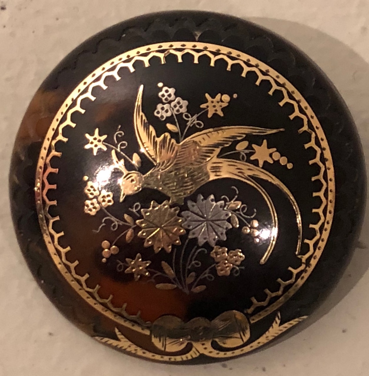 A VICTORIAN GOLD, TORTOISESHELL AND SILVER PIQUE CIRCULAR BROOCH With inlaid decoration of an exotic